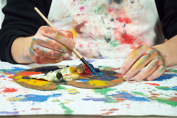 Naklejka premium Painter holding paintbrushes in his hands, close-up