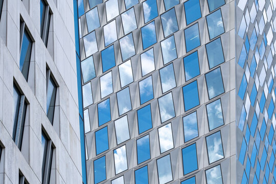 This image captures the dynamic reflections of clouds on a contemporary glass building, merging the architecture with nature in a striking visual contrast.