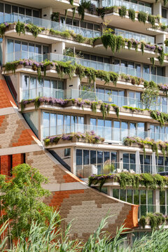 A beautifully designed building featuring lush greenery and floral accents, showcasing a harmonious blend of architecture and nature, promoting sustainable living practices in Amsterdam