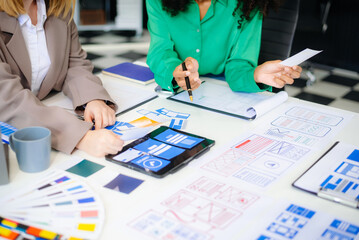  UX developer and ui designer brainstorming about mobile app interface wireframe design with...