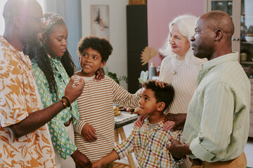 Biracial family chatting together before family dinner in elegant dining room