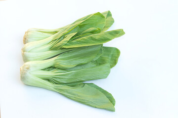 Crisp green pak choy leaves arranged on a white background for minimalist and fresh concepts.