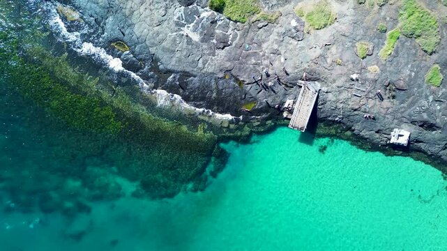 Drone aerial landscape of Bawley Point beach wharf pier dock jetty swimming spot along ocean coastline reef rocky headland South Coast Australia holidays tourism