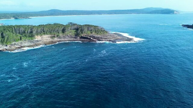 Drone aerial landscape of bushland forest and rocky reef Mill Point Wasp Island headland sea coastline of South Durras Australia wilderness outdoors travel tourism
