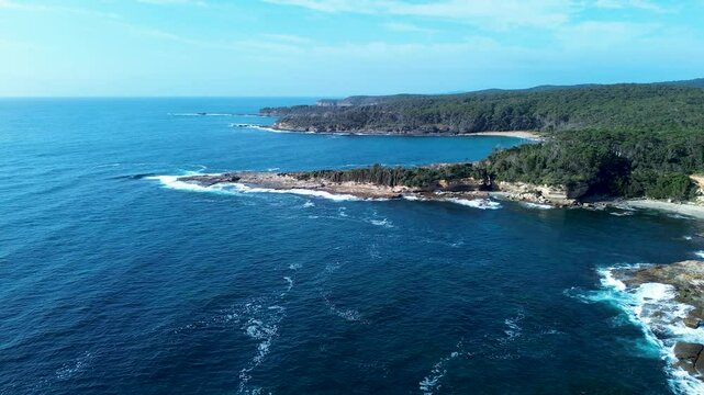 Drone aerial landscape South Durras Wasp head ocean coastline with waves breaking in bay cove and bushland trees Australia hiking trails Shoalhaven nature suburbs