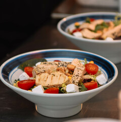 Ensalada de pollo, tomates cherry, queso griego y rúcula