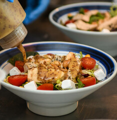 Ensalada de pollo, tomates cherry, queso griego y rúcula
