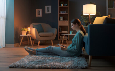 Young woman sitting on the floor and connecting with her tablet
