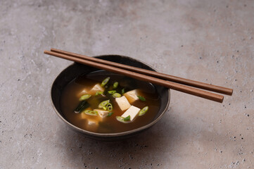 Traditional Japanese Miso soup with Wakame seaweed and tofu cheese with chopsticks for single...