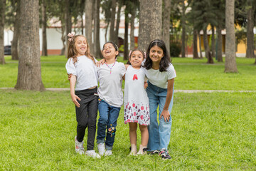 A group of young girls are posing for a picture in a park