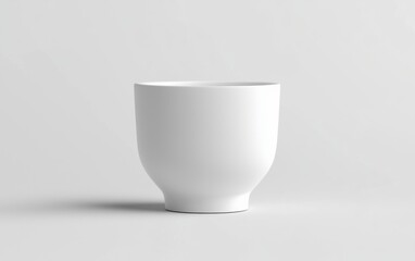 A simple white ceramic cup standing elegantly on a plain white background, minimalist style