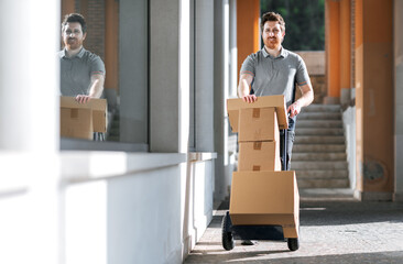 Professional delivery man transporting packages using a hand truck