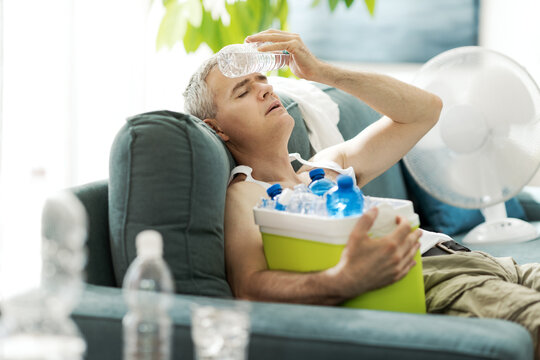 Exhausted man suffering from the heat at home