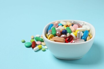 Various pills in a bowl on color background