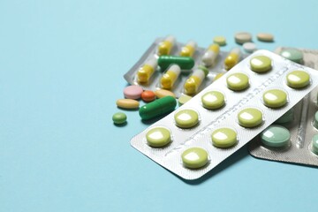 Pills in blister packs on blue background, close up