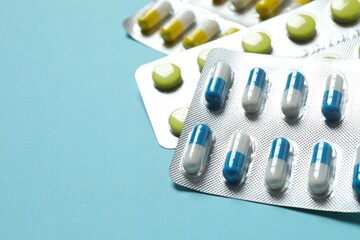 Pills in blister packs on blue background, close up