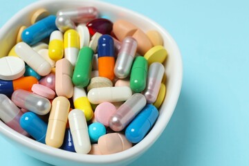 Various pills in a bowl on color background