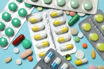 Pills in blister packs on blue background, close up