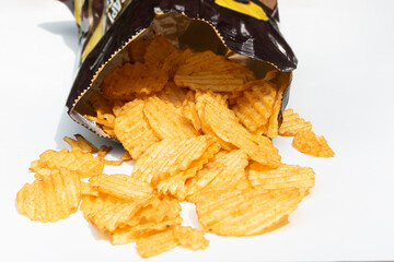 A pile of crunchy potato chips displayed on a white surface, highlighting their golden texture.