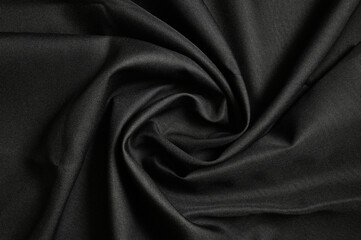 Fototapeta premium Black furniture fabric gunny background twisted in the middle. Top view.
