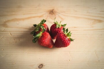 A photo of fresh strawberries isolated on a light wooden background