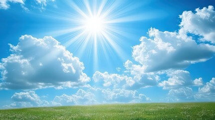 Fototapeta premium A clear blue sky with sunlight streaming through fluffy clouds, creating a dreamy atmosphere over a meadow.