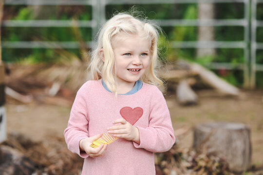 Happy little girl playing with slinky toy in the garden
