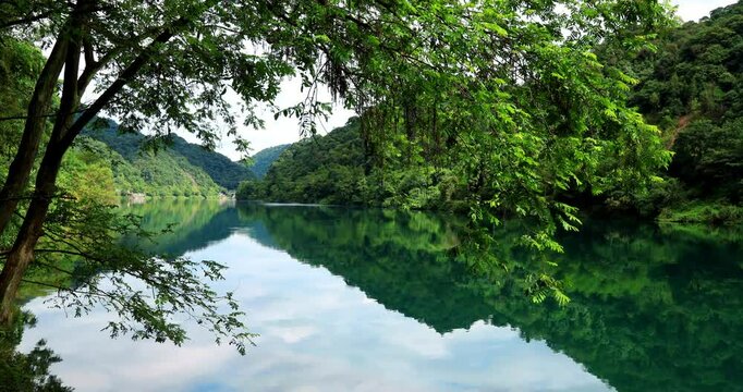Time lapse of Fog overflowed the Xiaodong River.The turquoise river, the floating fishing boat, and the diffuse white fog constitute a thick and heavy color ink painting. 