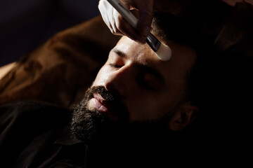 Facial, skin care, relaxation with a bearded man in the spa, beauty, mud, and hydrating mask....