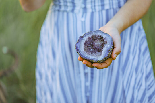 Close up image of Purple Amethyst Crystal held in woman's hands