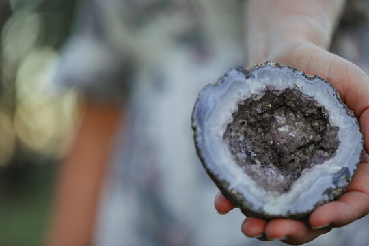 Close up image of Purple Amethyst Crystal held in woman's hand