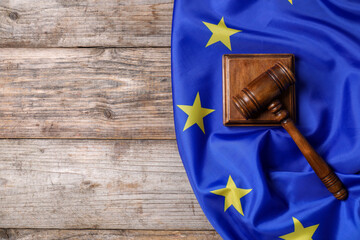 Judge's gavel and flag of European Union on wooden table, top view. Space for text