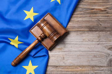 Judge's gavel and flag of European Union on wooden table, top view. Space for text