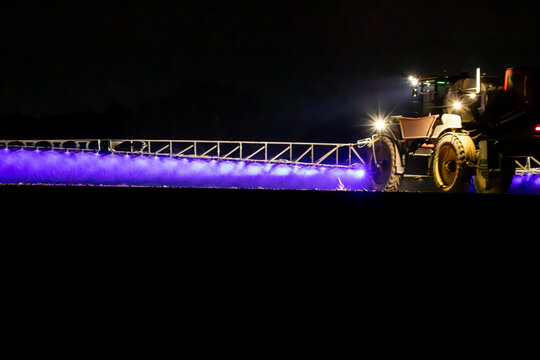 Self propelled boom sprayer spraying herbicide after planting canola
