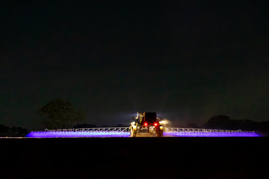 Self propelled boom sprayer spraying herbicide after planting canola