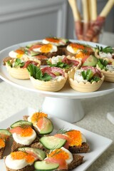 Many different tasty canapes on white table, closeup