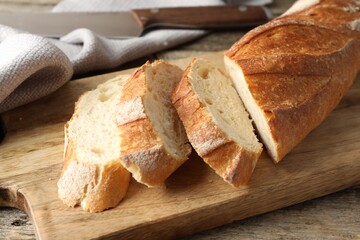 Pieces of fresh baguette on wooden table, closeup