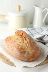 Loaf of delicious bread on white wooden table. Space for text