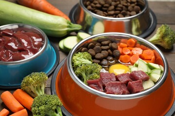Dry pet food and natural products on wooden table, closeup