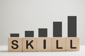 Upskill,Re-skilling,training,continuous learning,personal development concept.,SKILL word on wooden cubes with increasing chart idea for education,business.