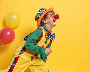 Funny kid clown playing against yellow background