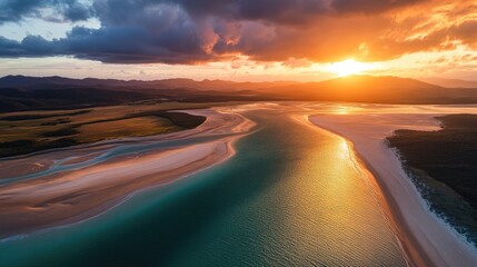 Aerial view of a tranquil lagoon bordered by sandy beaches glowing at sunset.