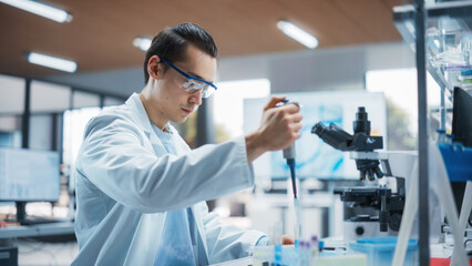 Medical Research Laboratory: Portrait of a Young Scientist Using Micropipette to Analyze Samples Under Microscope. Advanced Scientific School Course for Medicine and Microbiology Development