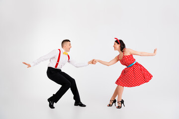 Full length photo of two young people hold arms enjoy dancing performance isolated on white color background