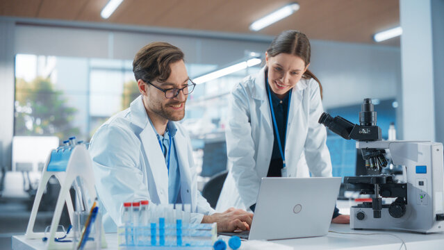 Scientists Working Together on a Research Project. Young Man and a Female in Modern Medical Laboratory Talking About Vaccine Development Methods, Gene Editing Studies, Biotechnology Breakthroughs