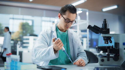 Medical Research Laboratory: Portrait of a Handsome Scientist Using Micropipette to Analyze Samples Under Microscope. Advanced Scientific Lab for Medicine, Biotechnology, Microbiology Development