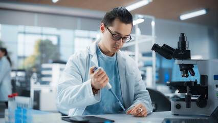 Medical Research Laboratory: Portrait of a Handsome Scientist Using Micropipette to Analyze Samples...