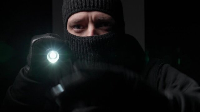 Gloved person with flashlight in dark setting