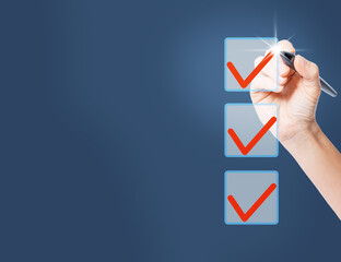 A woman's hand with a pen, marking the correct options out of three with a tick. 