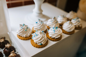 Fresh sweet decorated cupcakes, muffins with white cream on the table. Food photography, candy bar.